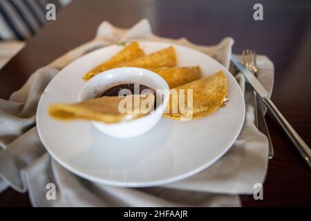 Piatto con quesadilla tradizionale e tazza di fagioli su tovagliolo grigio Foto Stock