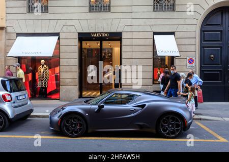 Un'auto sportiva parcheggiata accanto al negozio Valentino in Via Monte Napoleone, Milano. Italia. Foto Stock