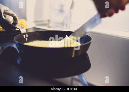 Cottura di crepe o pancake sottile in una padella. Foto Stock