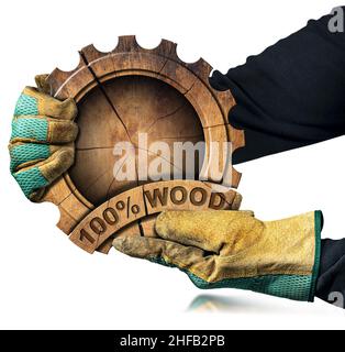 Mani con guanti da lavoro di protezione che reggono una ruota dentata di legno fatta da un tronco di albero con la frase corta, cento per cento legno, isolato su bianco. Foto Stock