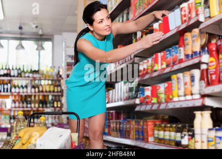 Passata di pomodoro in scatola sorridente per donna adulta Foto Stock