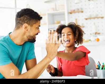 compiti di insegnamento ragazza alto cinque istruzione padre figli figlia familiarità infanzia successo bambino afroamericano Foto Stock