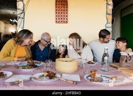 Felice famiglia latina divertirsi a pranzo insieme a casa Foto Stock