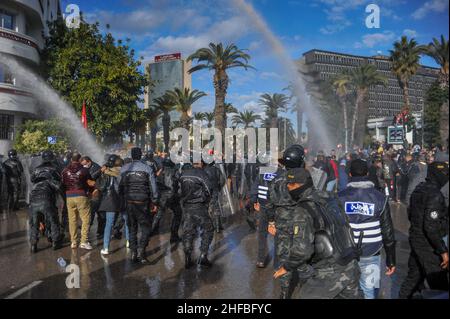 Tunisi, Tunisia. 14th Jan 2022. Tunisi, Tunisia. 14 gennaio 2022. I manifestanti si radunano contro il presidente Kais Saied in occasione del 10th° anniversario della rivoluzione del 2011. I manifestanti hanno sfidato il divieto di raduni e manifestazioni imposto per affrontare un forte aumento delle infezioni da Coronavirus, per esprimere il loro dissenso contro la sospensione del parlamento da parte del Presidente tunisino Kais Saied nel luglio 2021. I manifestanti hanno dovuto affrontare un pesante dispiegamento di forze di sicurezza, che hanno utilizzato cannoni ad acqua per disperderli (Credit Image: © Hasan Mrad/IMAGESLIVE via ZUMA Press Wire) Foto Stock