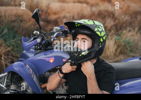 motociclista che mette sul casco Foto Stock