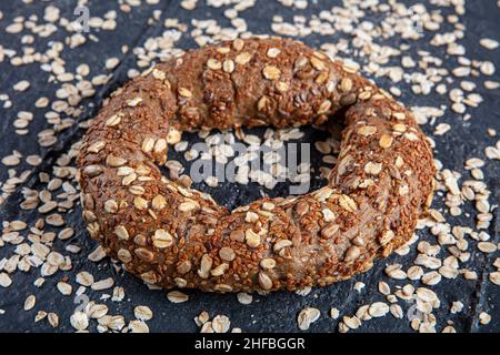 Bagel di farina d'avena con bagel (bagel di semi d'avena) su sfondo nero. Simit turco, croccante. Foto Stock