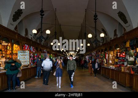 Cracovia, Polonia - 9th marzo 2020: Bancarelle del mercato, locali e turisti all'interno della Sala dei tessuti di Kraków. La Sala dei tessuti è la caratteristica centrale del mercato principale Foto Stock