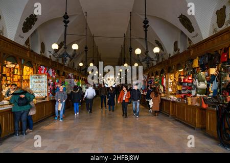 Cracovia, Polonia - 9th marzo 2020: Bancarelle del mercato, locali e turisti all'interno della Sala dei tessuti di Kraków. La Sala dei tessuti è la caratteristica centrale del mercato principale Foto Stock