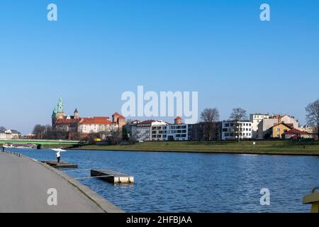 Cracovia, Polonia - 9th marzo 2020: Castello reale di Wawel a Cracovia, affacciato sul tranquillo fiume Vistula in una calda giornata di sole. Concetto di viaggio rilassante bac Foto Stock