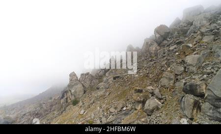 Vista aerea su montagne e rocce nella nebbia. Sfondo appannato con rocce Foto Stock