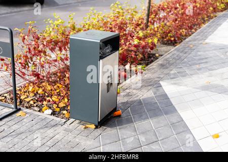 Contenitore in metallo con icona della lettiera, simbolo della lettiera nera sul bidone della spazzatura Foto Stock