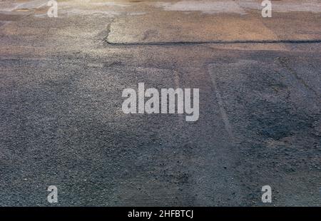 Una sezione di parcheggio con cemento e asfalto Foto Stock