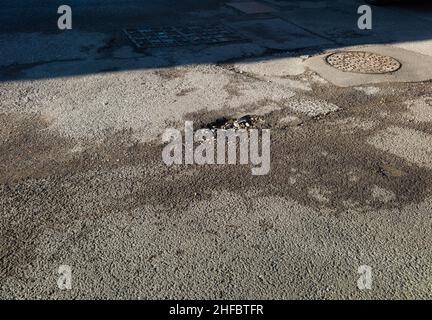 Una sezione di parcheggio con cemento e asfalto Foto Stock