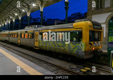 Porto, Portogallo - 18 Nov 2020: Vecchi treni vintage grigio e giallo al capolinea della stazione ferroviaria di Sao bento a Porto. I treni sporchi alla stazione aspettano Foto Stock