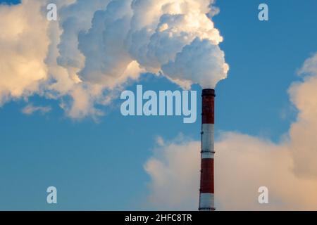 Fumo proveniente dai tubi degli impianti di calore ed energia sulla città invernale. Inquinamento atmosferico. Spazio di copia Foto Stock