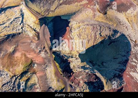 Cratere vulcanico e i campi lavici della regione di Berserkjahraun, Penisola di Snaefellsnes, Islanda. Si può vedere una strada sterrata che si snoda. Foto Stock