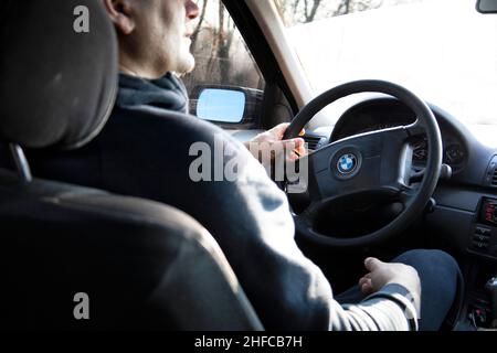 Conducente con un telefono dietro il volante Foto Stock