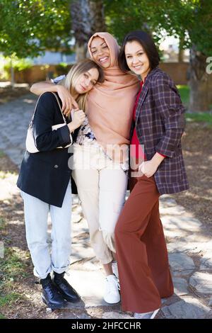 Le giovani e le ragazze sono entusiasti di abbracciare e sorridere nel parco Foto Stock