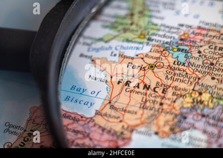 La Francia su una mappa del mondo attraverso una lente d'ingrandimento. Francia destinazione di viaggio pianificazione bloccato Foto Stock