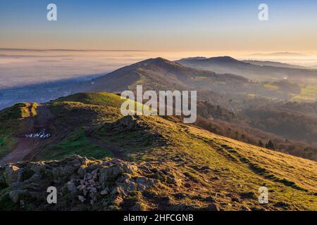 Rocce di granito illuminate dal sole a Worcestershire Beacon nel pomeriggio invernale a Malverns, Inghilterra Foto Stock