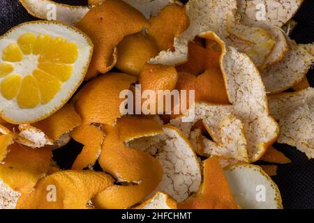 Bucce di mandarino. Immondizia organica su sfondo nero Foto Stock