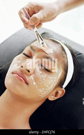 Donna che riceve un rinfrescante trattamento viso naturale presso il padiglione relax all'aperto della Rebab Spa a Kayumanis Gangsa, Bali, Indonesia. Foto Stock