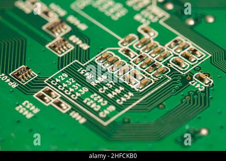 Molti piccoli componenti elettronici saldati su una scheda a circuito stampato (PCB) verde. Foto Stock