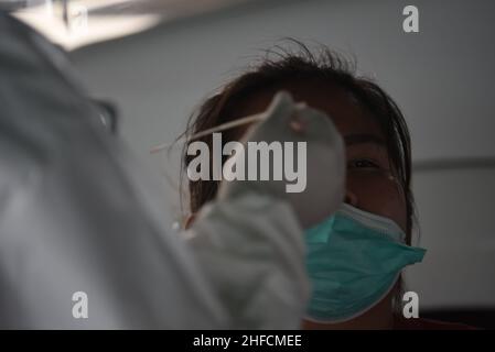 Bangkok, Tailandia. 15th Jan 2022. Operatori sanitari della Metropolitan Administration di Bangkok, indossando uniformi PPE, utilizzando Rapid Antigen Test, tampone di cotone per raccogliere campioni da persone a rischio di contrarre Covid-19 presso i punti di servizio pubblico in formato Drive-Thru e walk-in presso il Bangkok Bus Terminal (Borommaratchachonnani) a Bangkok gratuitamente. (Credit Image: © Teera Noisakran/Pacific Press via ZUMA Press Wire) Foto Stock