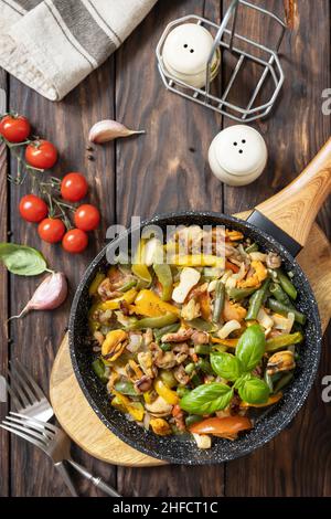 Ragù di pesce, sana cena mediterranea. Gamberetti di mare, calamari, seppie stufati di verdure e salsa all'aglio in una padella, su un woo Foto Stock