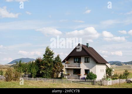 Casa in pietra bianca in una valle con montagne sullo sfondo. Montenegro, nord Foto Stock