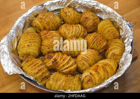 Patate al forno a fisarmonica nella pentola. Concetto di cucina domestica. Foto Stock