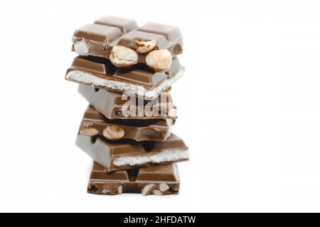 I pezzi di cioccolato di diversi tipi accatastati su sfondo bianco. Foto Stock