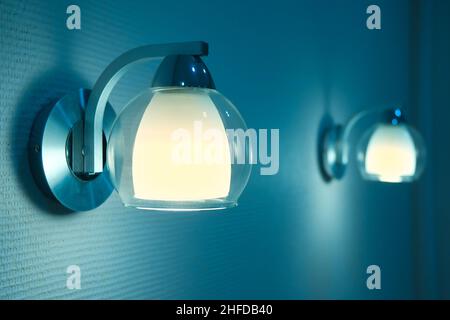 Coppia di lampade in camera da letto. L'immagine dei toni blu e giallo di due luci notturne. Foto Stock