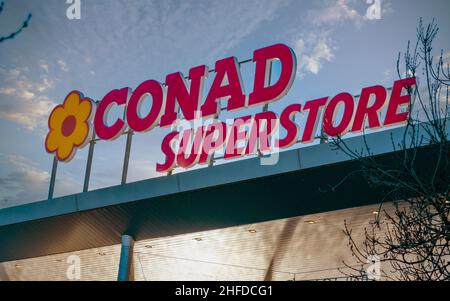 Savigliano, Cuneo, Italia - 14 gennaio 2022: Il logo Conad Superstore sul cielo nuvoloso blu, Conad (Consorzio Nazionale Retail) è il primo su larga scala Foto Stock