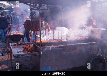 I venditori ambulanti cambogiani al macedone di carne di Smokey durante il capodanno cinese, mercato di Kandal, Phnom Penh, Cambogia. © Kraig Lieb Foto Stock