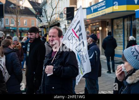 Amstetten, Austria - Gennaio 15 2022: Sostenitore di MFG Menschen Freiheit Grundrechte Party che detiene la bandiera per protesta o demosntrazione contro obbligatorio Foto Stock