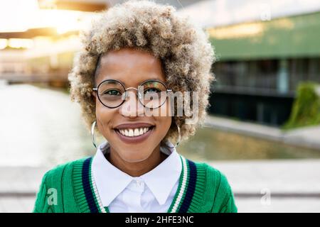 Ritratto della giovane donna ispanica latina con acconciatura afro guardando la macchina fotografica Foto Stock