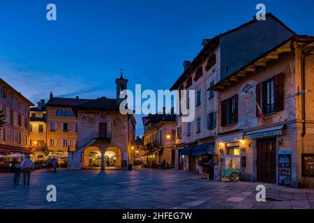 Piazzetta Ernesto ragazzi, la piazza principale di Orta San Giulio, con ristoranti e negozi circostanti illuminati di notte. Foto Stock