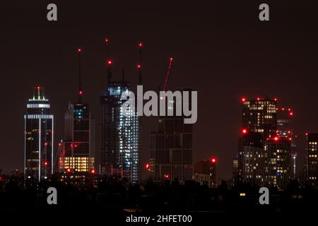 Gru e alti edifici, tra cui la St Georges Tower on Uno skyline di Londra di notte Foto Stock