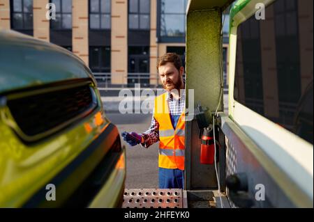 Uomo che lavora nel servizio di traino su strada Foto Stock