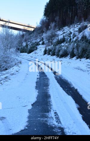 piste di gomma nella neve su una strada rurale Foto Stock