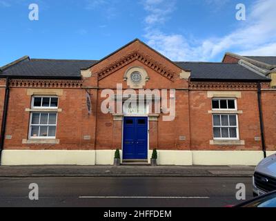 Mercato vegetariano a Wolverton Milton Keynes UK stazione ferroviaria bagni bagni bagni vecchio segno segni mattoni edificio stile vittoriano storico porta blu Foto Stock