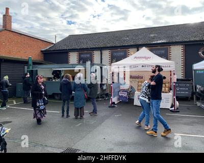 Mercato vegetariano a Wolverton Milton Keynes Regno Unito Vegan bancarelle mercato al di fuori del menu del cibo persone che guardano l'acquisto e mangiare parcheggio a pranzo Foto Stock