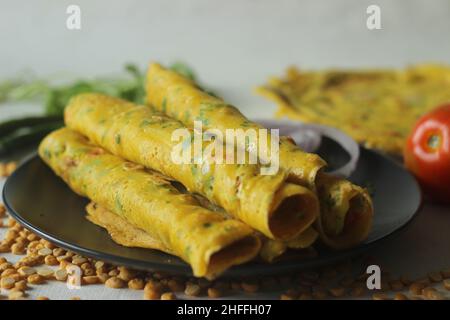 Frittelle di ceci o chickpea besan. Si tratta di pancake salati ricchi di proteine, fatti di farina di besan o farina di ceci con cipolle, pomodoro, peperoncino verde e. Foto Stock