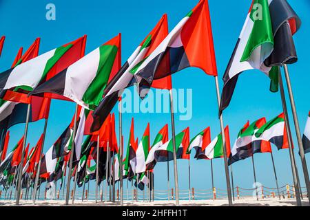 Bandiere degli Emirati Arabi Uniti ondeggianti nel vento su una spiaggia di aquiloni a Dubai. Foto Stock