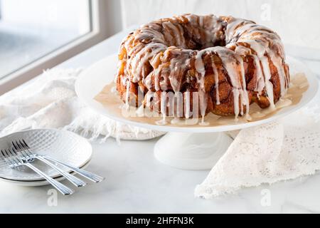 Una torta al caffè con cannella di mele a strappo, condita con glassa, pronta per essere servita. Foto Stock