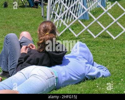 Due ragazze teen che posano sull'erba Foto Stock