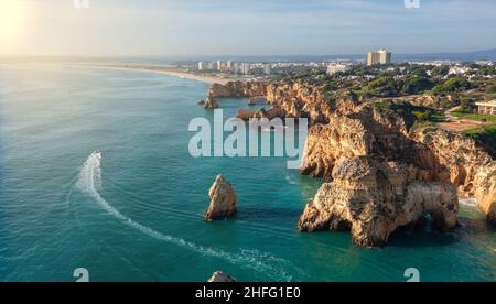 Vista aerea delle belle spiagge portoghesi con spiagge di sabbia rocciosa e sabbia pura per i turisti ricreazione nell'Algarve nel sud. Giorno di sole Foto Stock