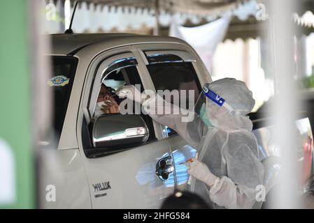 Bangkok, Tailandia. 15th Jan 2022. Operatori sanitari della Bangkok Metropolitan Administration, indossando le uniformi PPE, utilizzando Rapid Antigen Test, tampone di cotone per raccogliere campioni da persone a rischio di contrarre Covid-19 presso i punti di servizio pubblico in formato Drive-Thru e walk-in presso il Bangkok Bus Terminal a Bangkok, Thailandia il 15 gennaio 2022 gratuitamente. (Foto di Teera Noisakran/Pacific Press/Sipa USA) Credit: Sipa USA/Alamy Live News Foto Stock