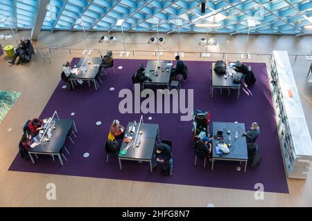 I visitatori utilizzano le strutture del piano principale "Living Room" della Seattle Central Library nel centro di Seattle. Foto Stock